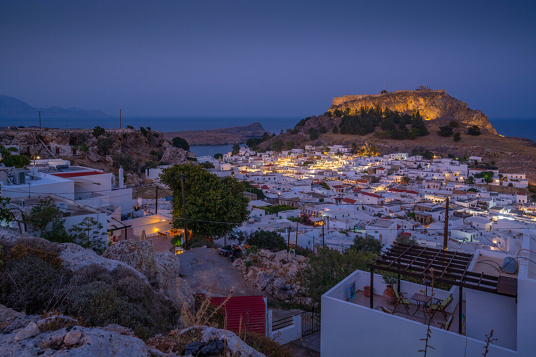Blick auf Lindos und die Akropolis von Lindos von erhöhter Position in der Abenddämmerung, Lindos, Rhodos, Dodekanes-Inselgruppe, Griechische Inseln, Griechenland, Europa