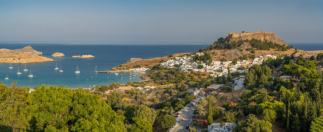 Blick auf Segelboote in der Bucht, Lindos und Lindos Akropolis von erhöhter Position, Lindos, Rhodos, Dodekanes Inselgruppe, Griechische Inseln, Griechenland, Europa