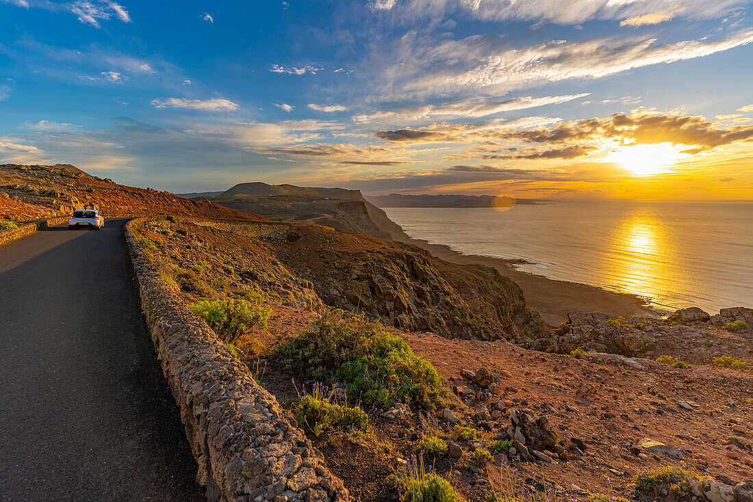 Blick auf Straße und Vulkanküste vom Mirador del Rio bei Sonnenuntergang, Lanzarote, Las Palmas, Kanarische Inseln, Spanien, Atlantik, Europa
