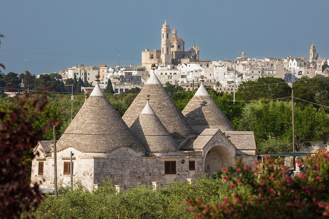 Locorotondo town and Chiesetta Rettoria Maria SS Annunziata church on hilltop with trulli house below in the Valle d'Itria, Locorotondo, Puglia, Italy, Europe