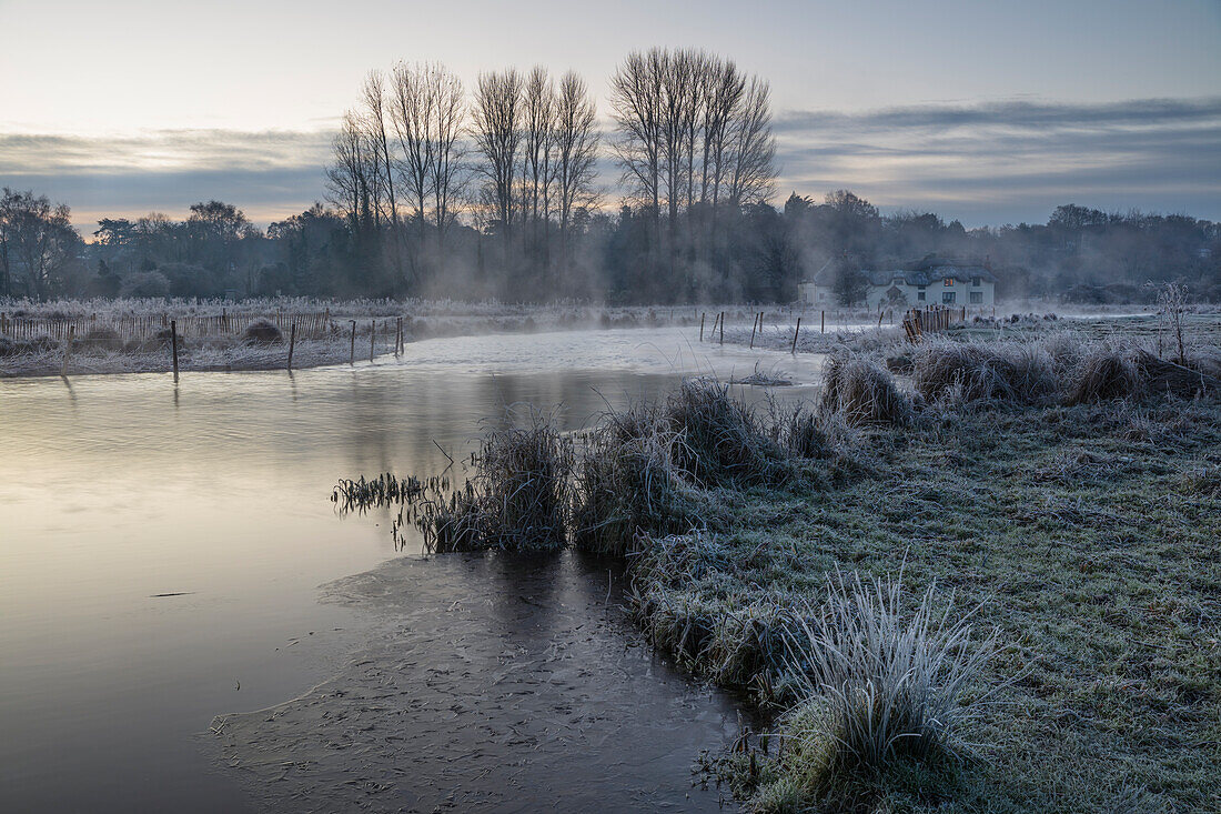 Frostiger Wintersonnenaufgang mit Nebel auf dem Fluss Test am Chilbolton Cow Common SSSI (Site of Special Scientific Interest), Wherwell, Hampshire, England, Vereinigtes Königreich, Europa