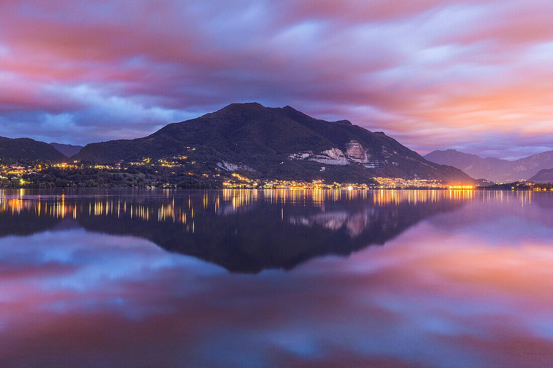 Dawn on Cornizzolo mount reflected on Pusiano lake, Lecco province, Lombardy, Italy, Europe