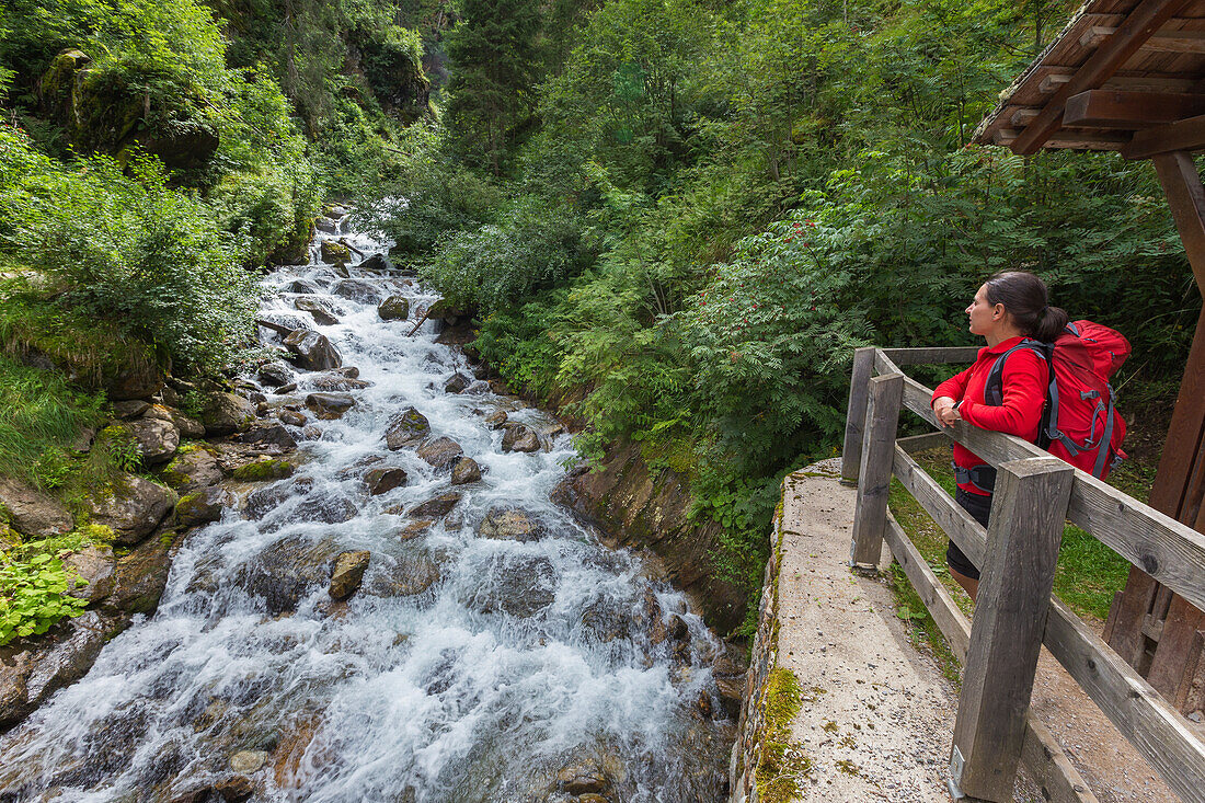 Wanderer entspannt sich und schaut auf den Fluss, Rabbital (val di Rabbi), Provinz Trient, Trentino-Südtirol, Italien, Europa (MR)