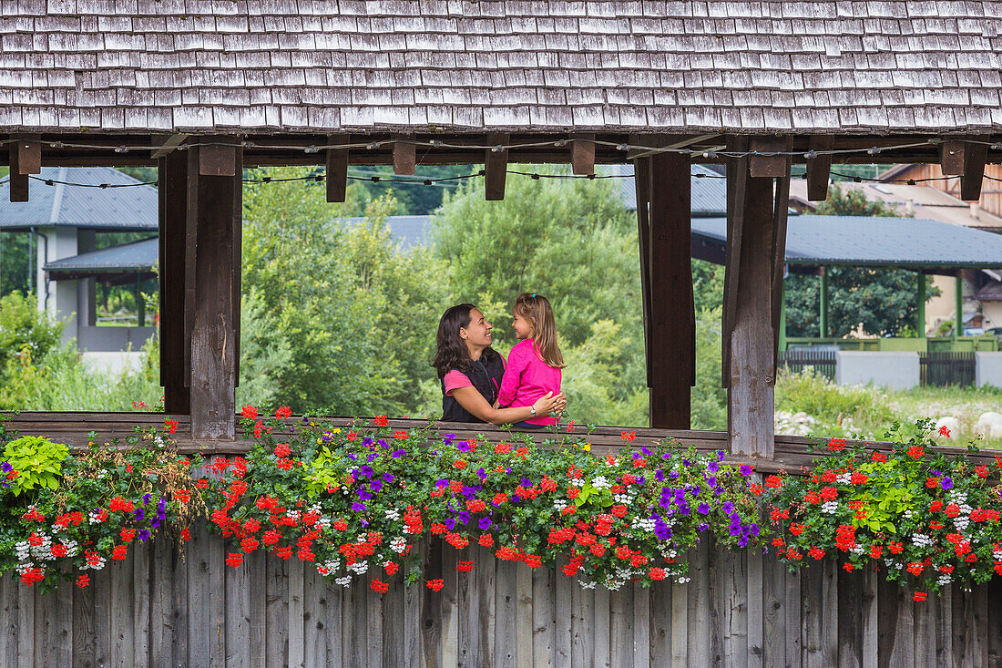 Mutter und Tochter umarmen sich auf der Holzbrücke (Ponte di Legno di Pellizzano) im Sommer, Pellizzano, Sohlental (val di Sole), Provinz Trient, Trentino-Südtirol, Italien, Europa (MR)