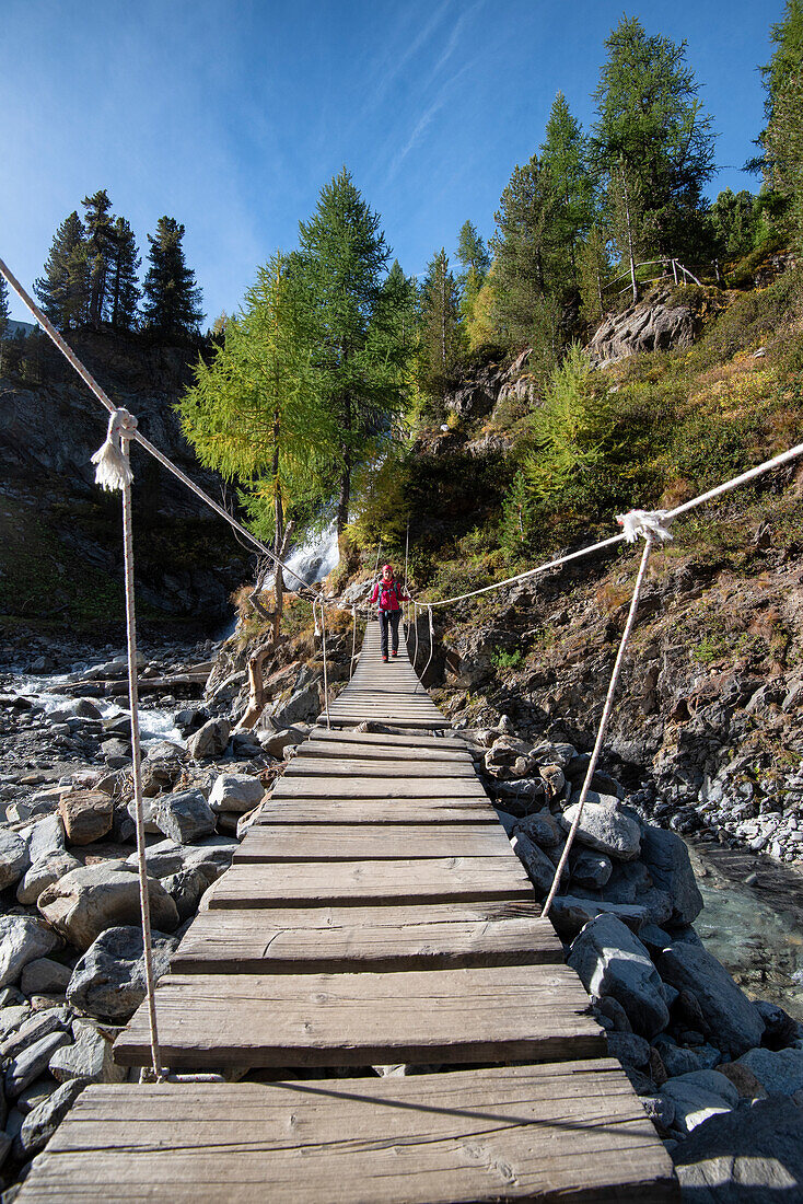 Wanderer auf der tibetischen Brücke in der Nähe des Wasserfalls von Val Nera, Livigno, Sondrio Provinz, Valtellina, Lombardei, Italien, Europa