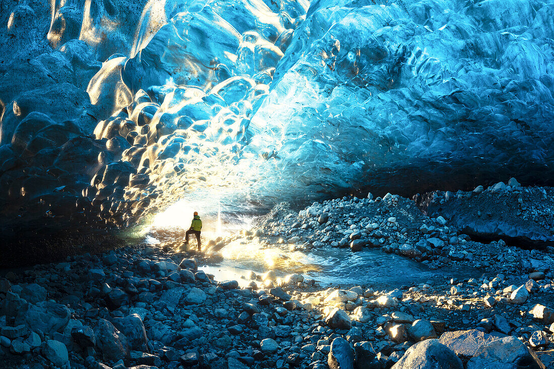 ein Wanderer bewundert eine Eishöhle in der Jokusarlon Glacier Lagoon Gegend im Winter, Austurland, Island, Europa