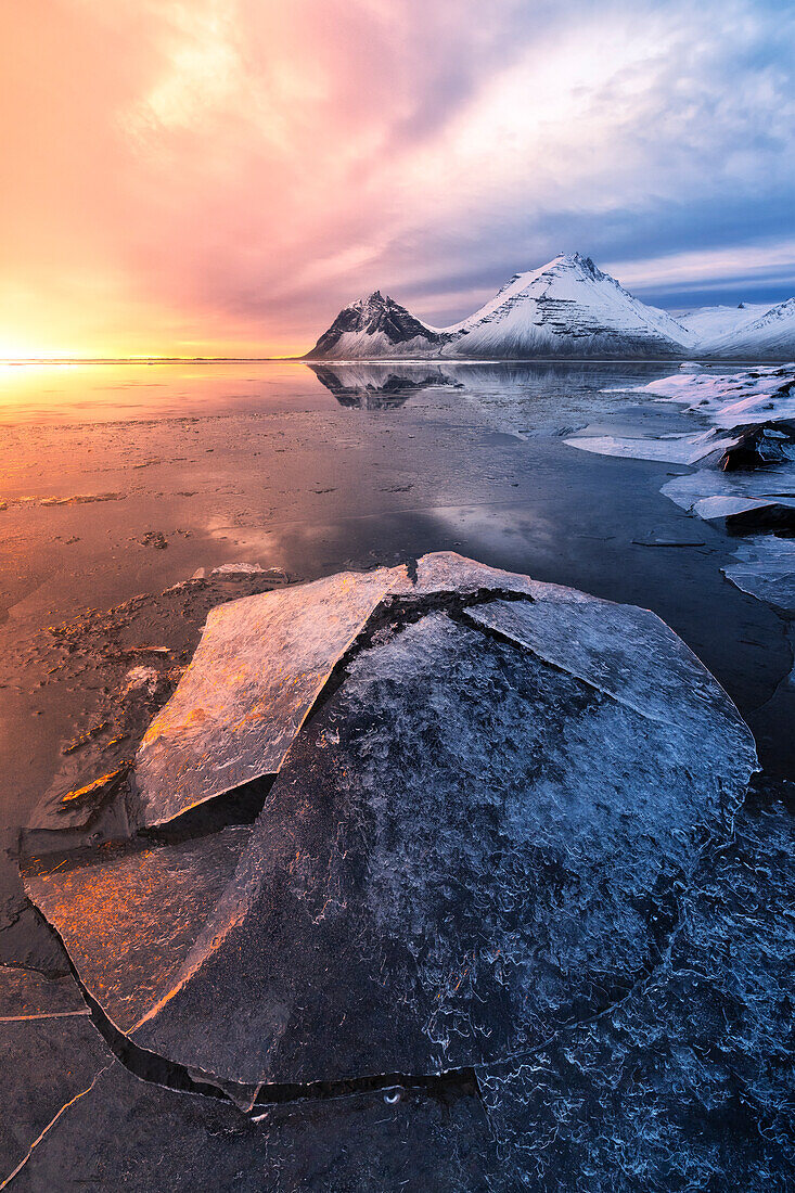 Das Vestrahorn spiegelt sich in der Bucht während eines Wintersonnenaufgangs, Austurland, Südisland, Europa
