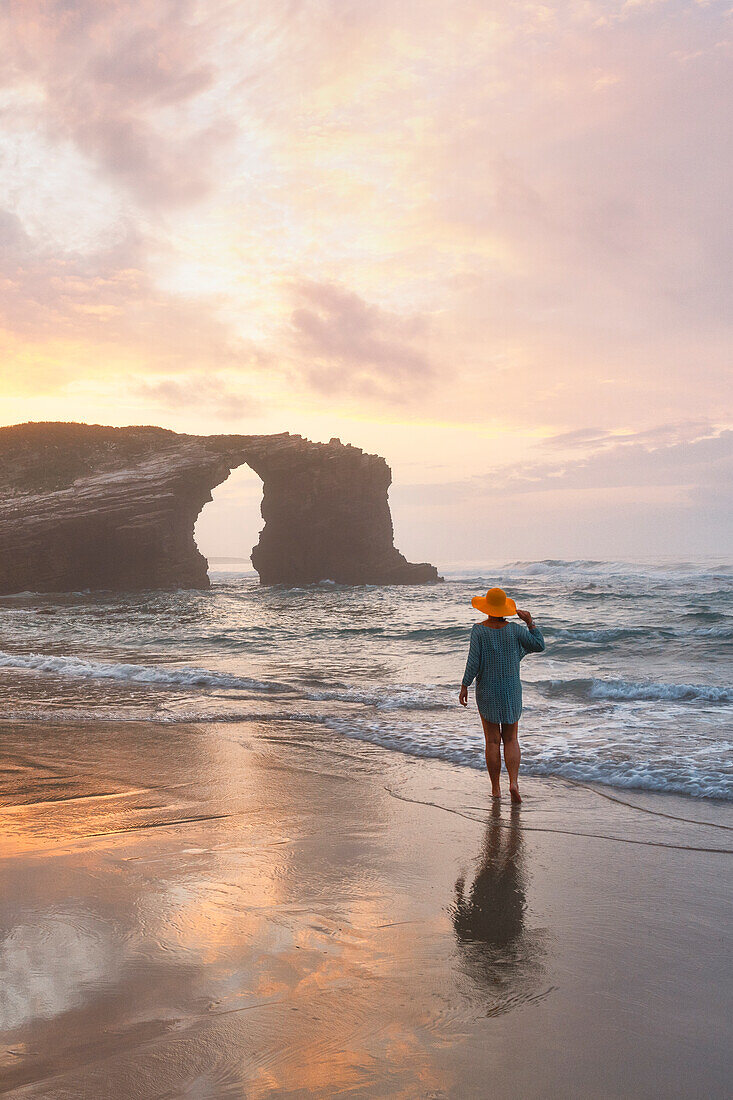 ein Tourist genießt einen herrlichen Sonnenuntergang am Praia at Catedrais bei Ebbe, Galixia, Spanien, Europa