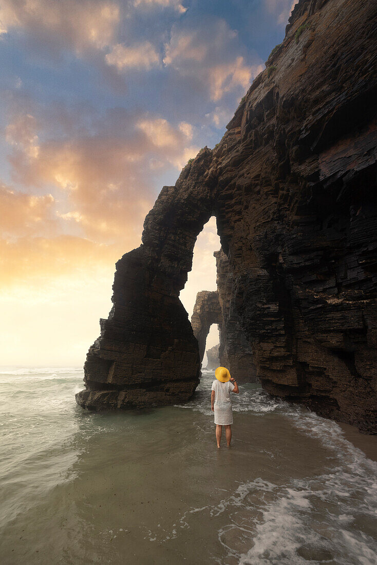 one tourist enjoy an amazing summer sunset at Praia at Catedrais during a low tide, Galixia, Spain, Europe