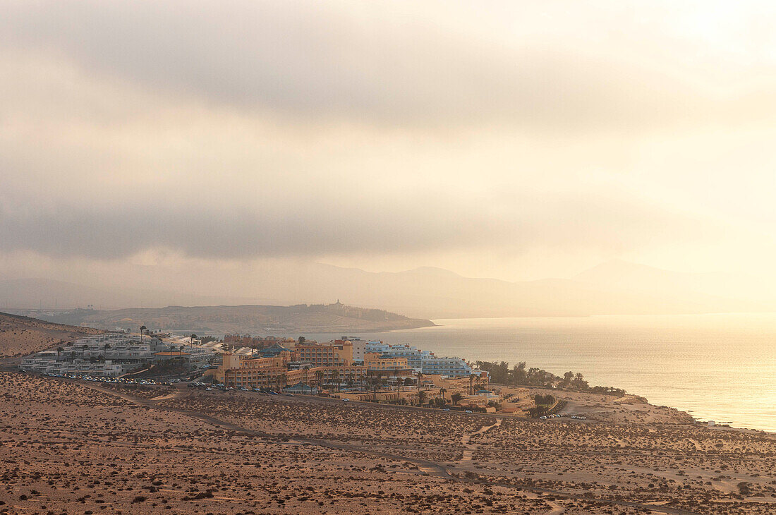 ein warmes Licht umhüllt die Küstenstadt Costa Calma während eines Sonnenaufgangs im Sommer, Fuerteventura, Kanarische Insel, Spanien, Europa