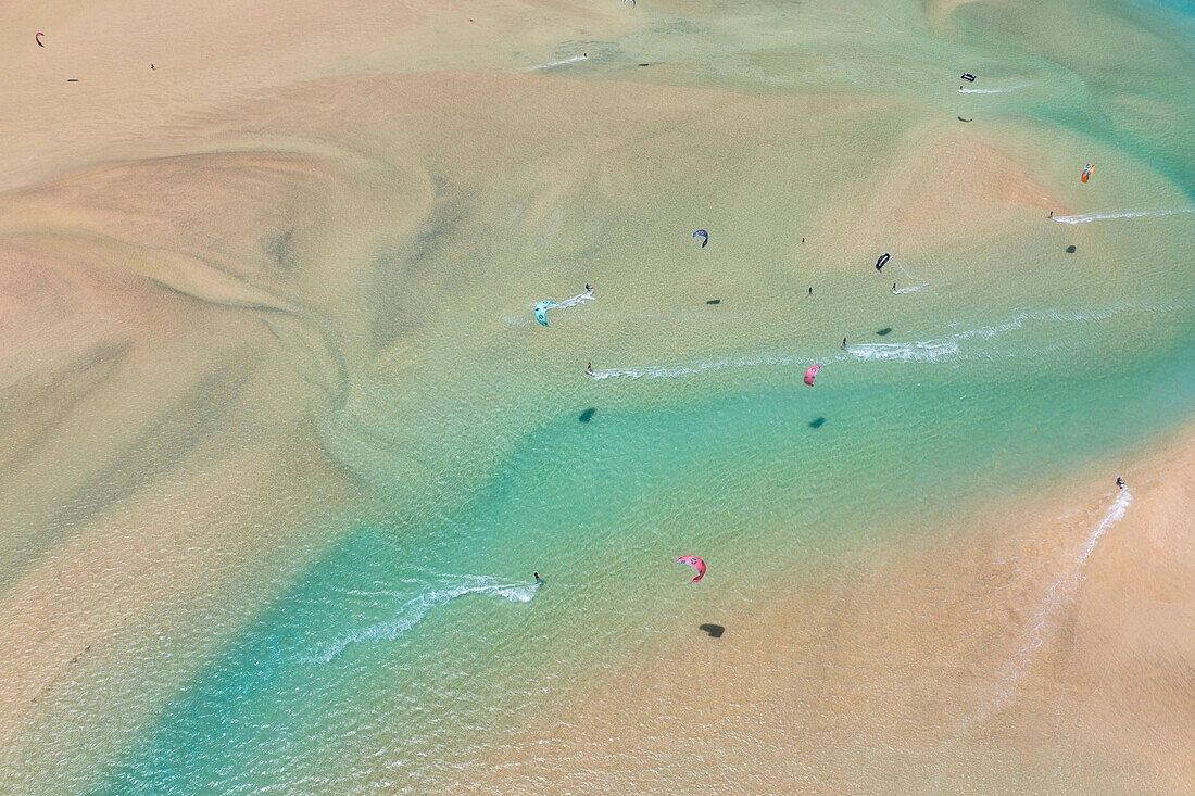 Luftaufnahme einer Drohne von einem schönen Strand von Sotavento an einem sonnigen Sommertag, mit vielen Kitesurfern, Fuerteventura, Kanarische Insel, Spanien Europa