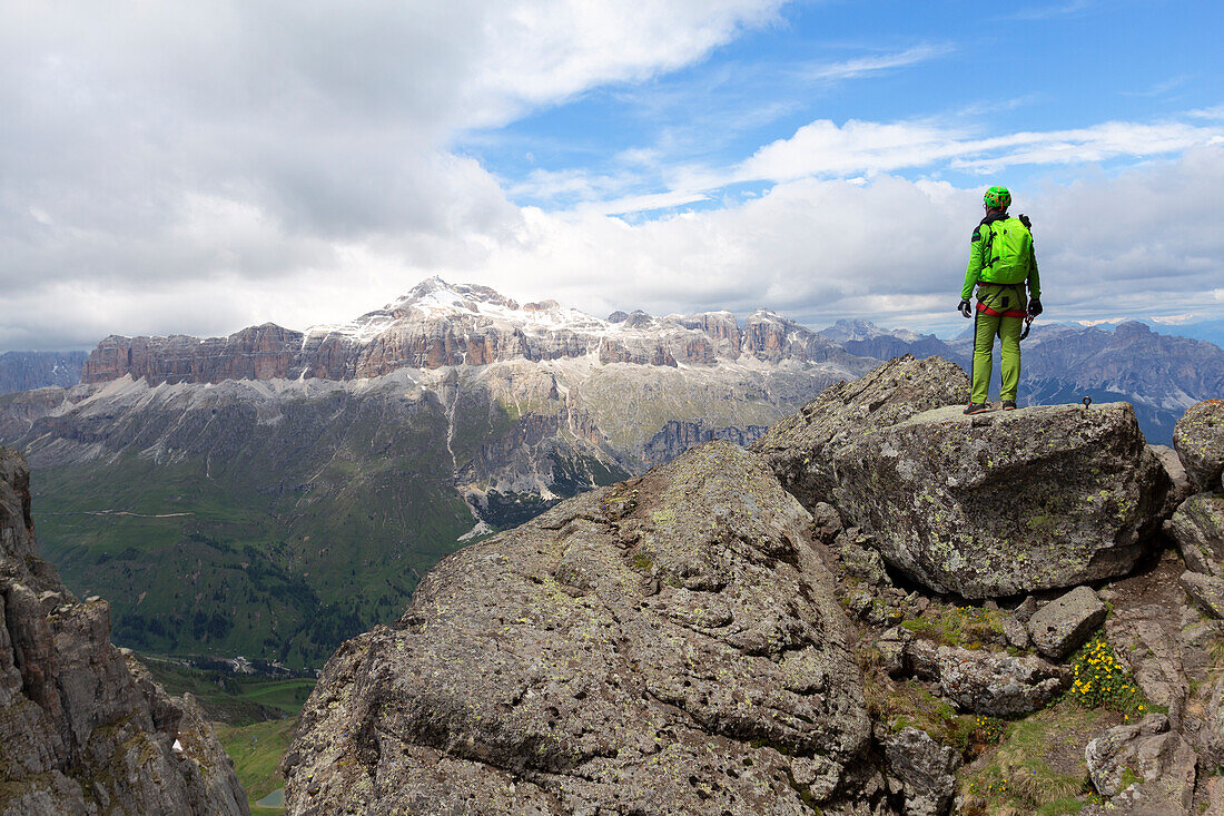 A hiker observes the Sella Group along the Via Ferrata delle Trincee, Padon Group, Dolomites, Fassa Valley, Trento Province, Trentino-Alto Adige, Italy.