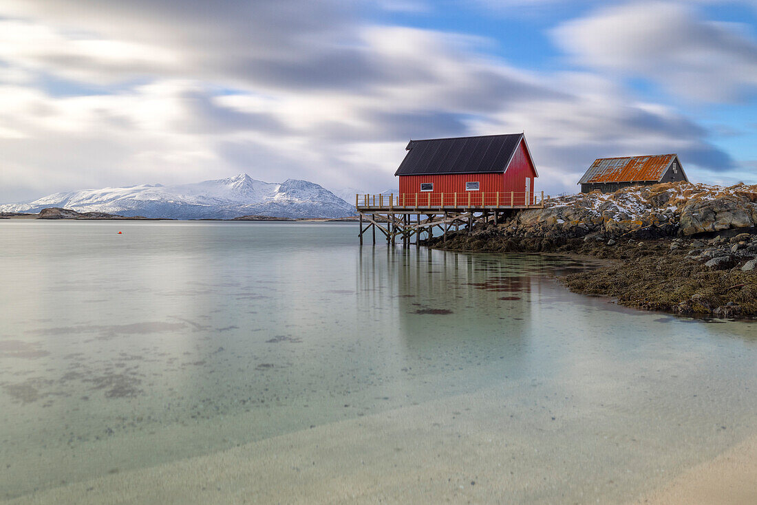 eine klassische Rorbuer entlang der Küste der Insel Hillesoya an einem bewölkten Wintertag, Hillesoya, Troms, Norwegen, Europa