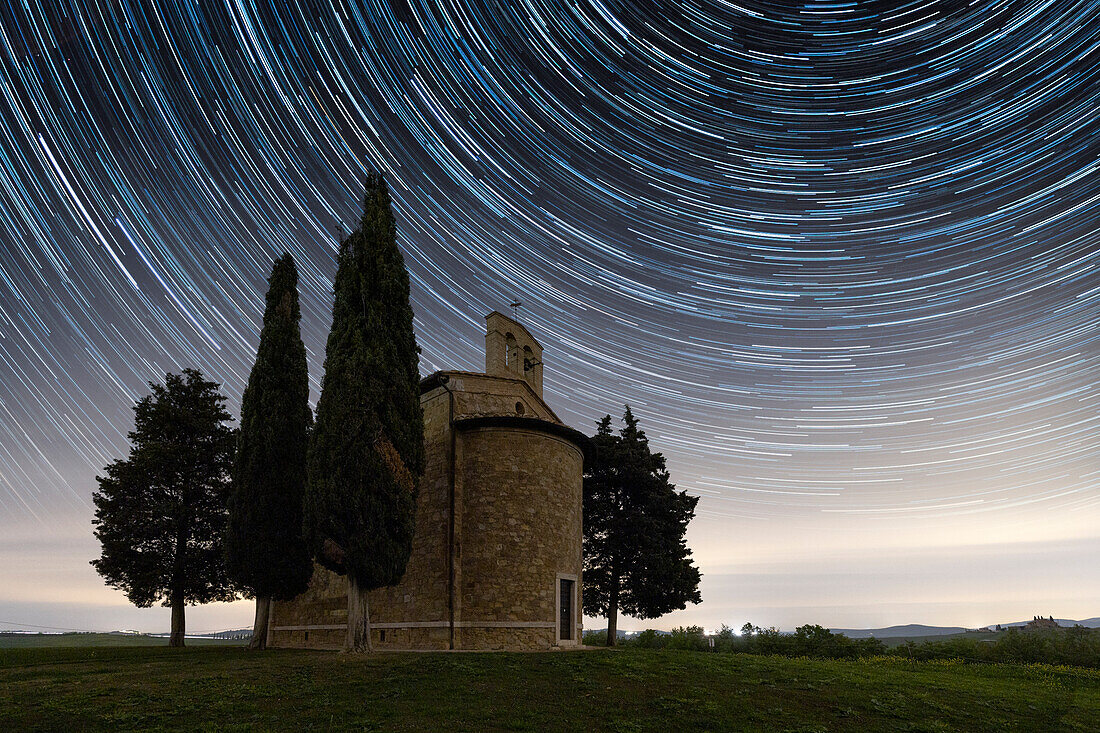 Sternenspuren an der Vitaleta-Kapelle während einer Frühlingsnacht, San Quirico d'Orcia, Provinz Siena, Toskana, Italien, Europa