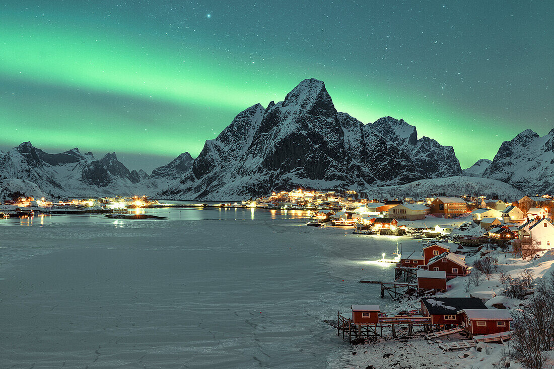 eine Person genießt die Magie des arktischen Himmels mit den Nordlichtern bei Reine Lofoten, Norwegen, Europa