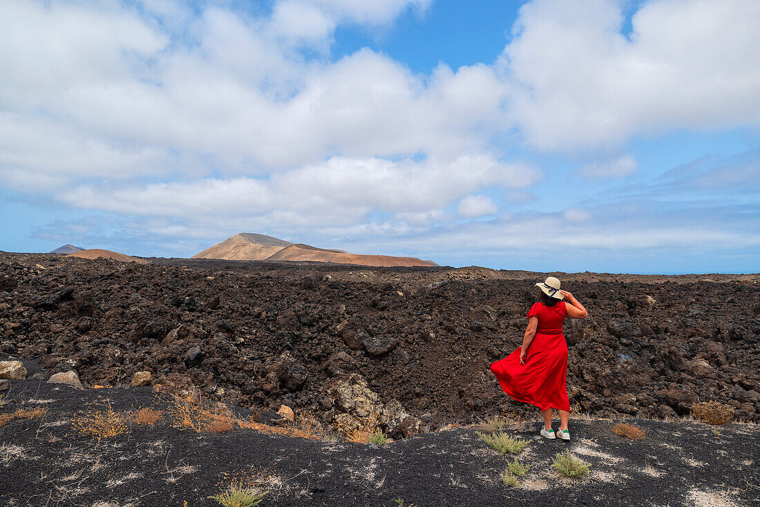 Ein Tourist genießt die schöne Aussicht bei einem Spaziergang über das Lavafeld in der Nähe des Vulkans Caldera Blanca, Lanzarote, Kanarische Insel, Spanien, Europa