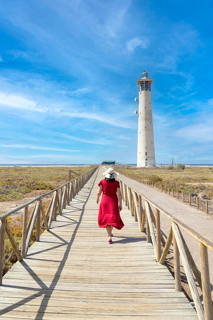 a tourist admires the view near the Morro Jable lighthouse during a sunny summer day, Fuerteventura, Canary Island, Spain, Europe