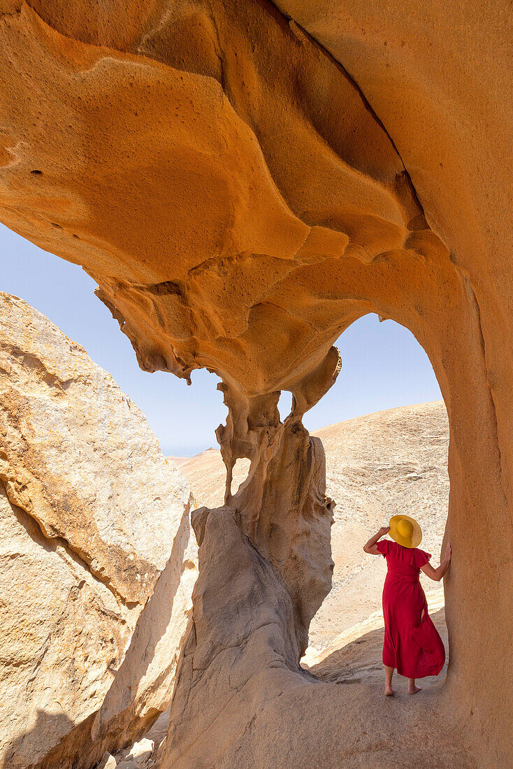 a tourist admires the view from the cave at Vega de Rio Palma during a sunny summer day, Fuerteventura, Canary Island, Spain, Europe