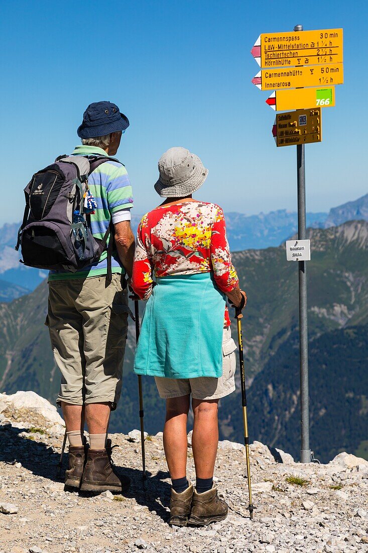 Rentnerpaar auf dem Weg zu einer Wanderung auf dem Weisshorn in den Schweizer Alpen, aktive Senioren, Tourismus, Ferienort Arosa, Kanton Graubünden, Schweiz