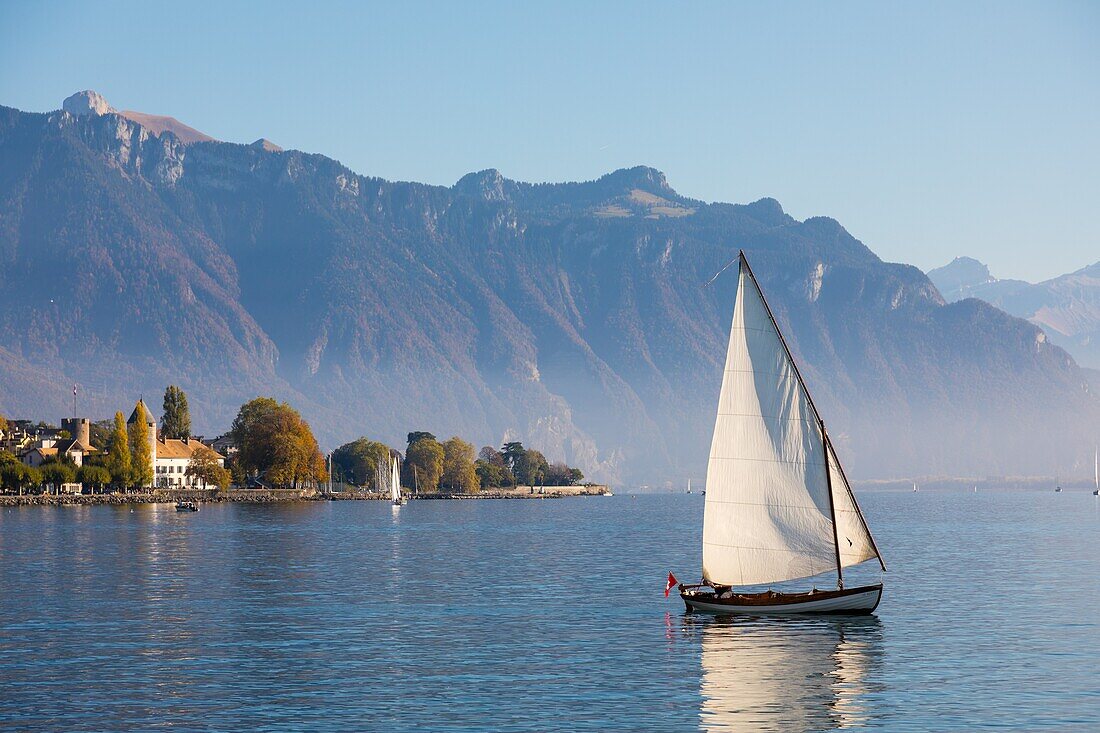 Boot auf dem Genfer See mit dem Schloss, das das Schweizerische Museum der Spiele beherbergt, und den Schweizer Alpen im Hintergrund, Vevey, Kanton Waadt, Schweiz