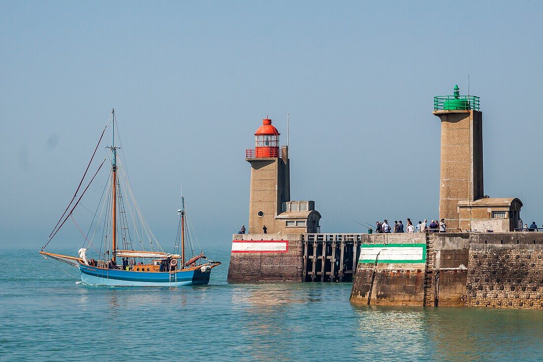 Fishing port leaving the port of fecamp under the gaze of the tourists and fishermen fishing on the jettie, lighthouse of fecamp, fecamp, seine-maritime, normandy, france