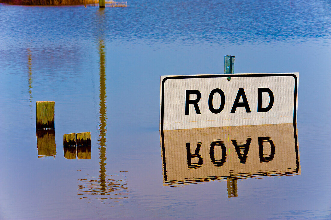 Road closed sign reflected in flood waters.