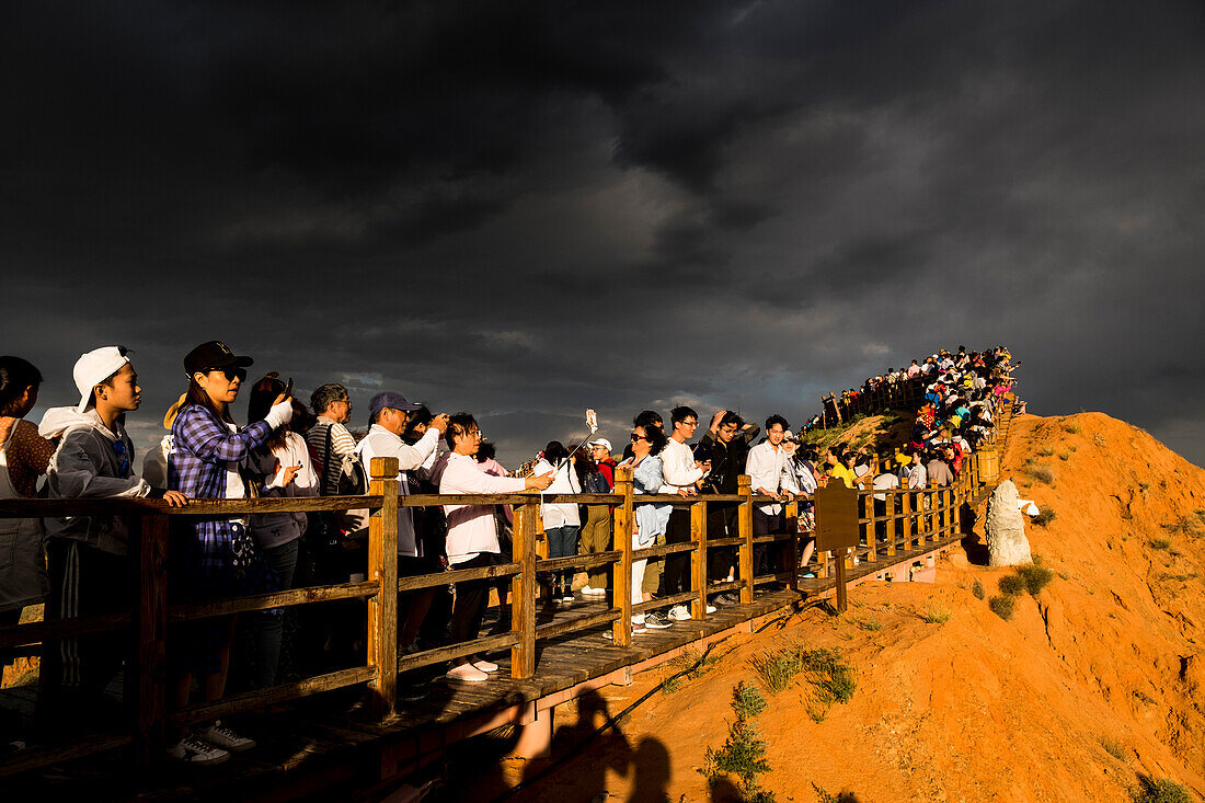 Chinesische Touristen besuchen die Regenbogenberge des geologischen Nationalparks Zhangye Danxia
