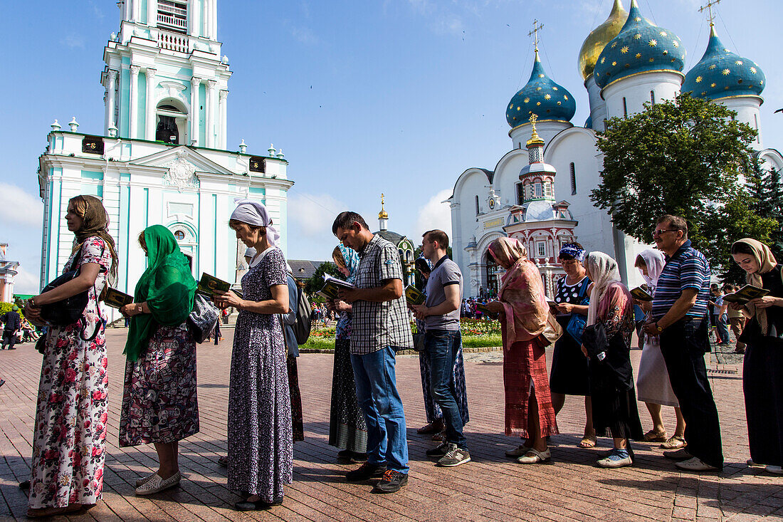 Religious faithful praying within the monastic complex of the Trinity Lavra of St. Sergius in Sergiyev Posad