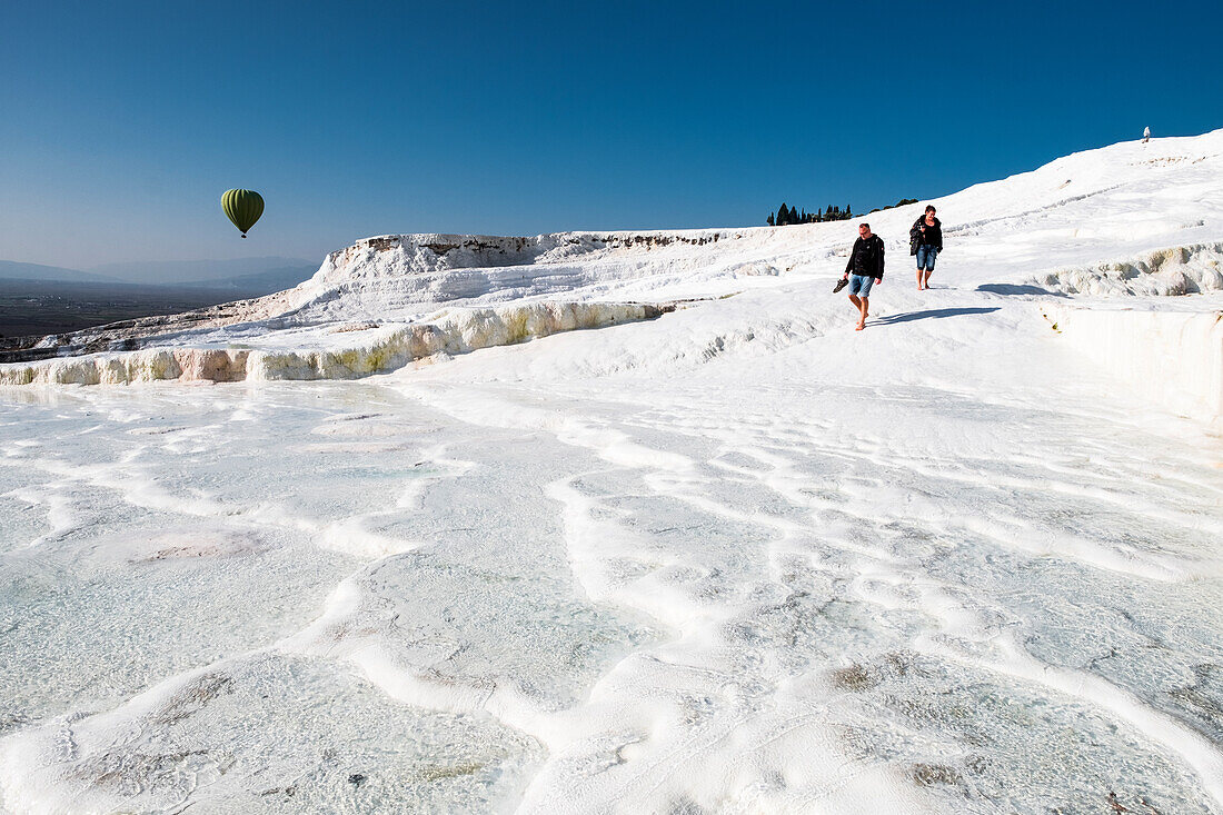 Travertin-Terrassenformationen in Pamukkale, Touristen und Heißluftballon