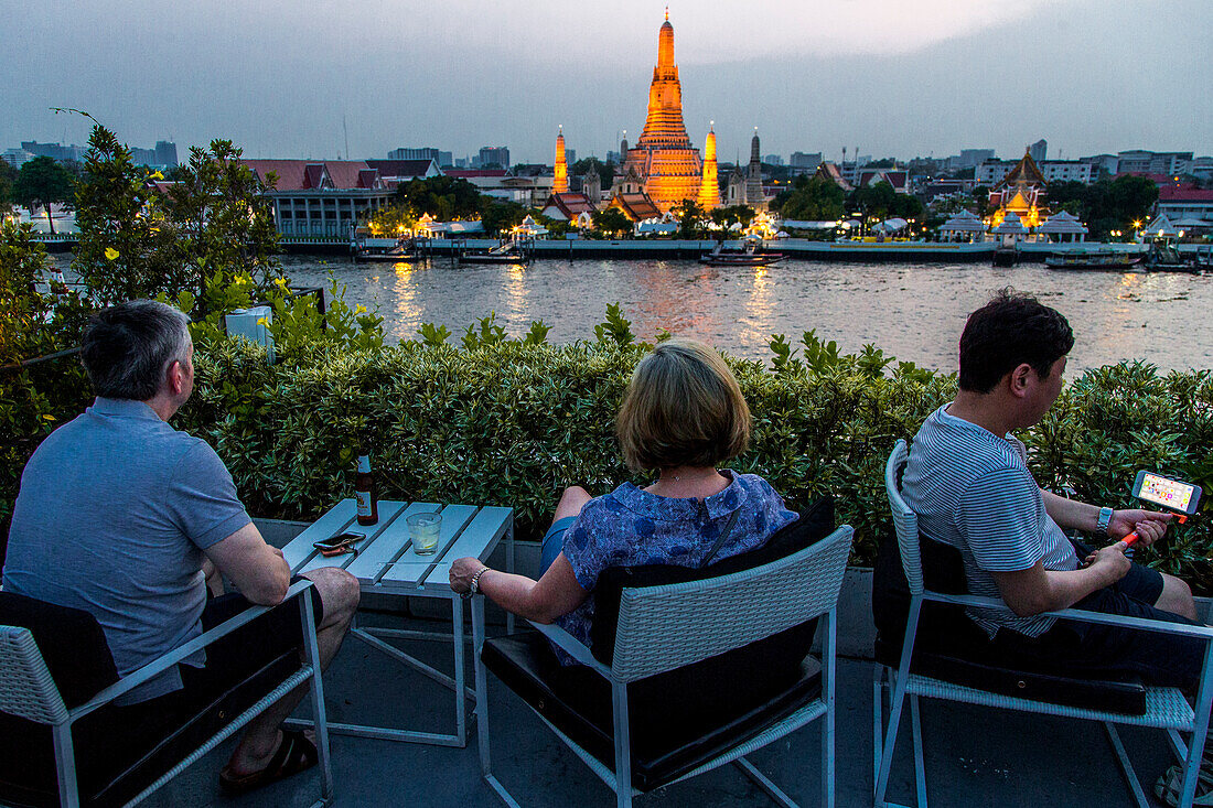 Ein Drink in einer Bar mit Blick auf den Wat Arun Tempel, von der anderen Seite des Chao Praya Flusses