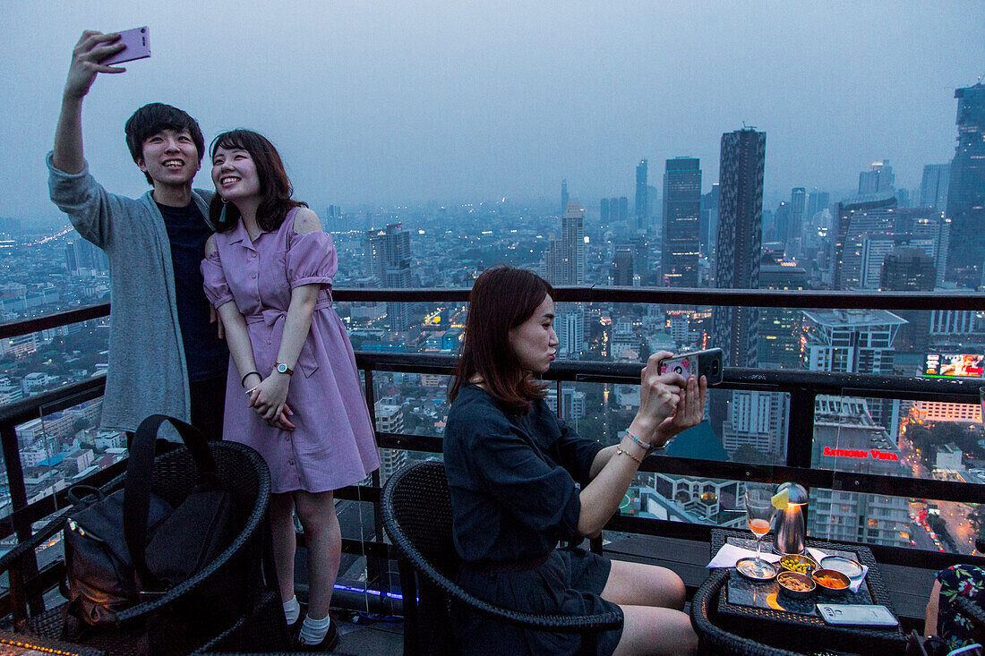 Selfie bei Sonnenuntergang über Bangkok von der Terrasse des Banyan Tree Hotels