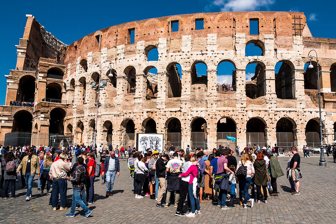 Tourists outside the Colosseum or Coliseum, the most famous landmark from ancient Rome