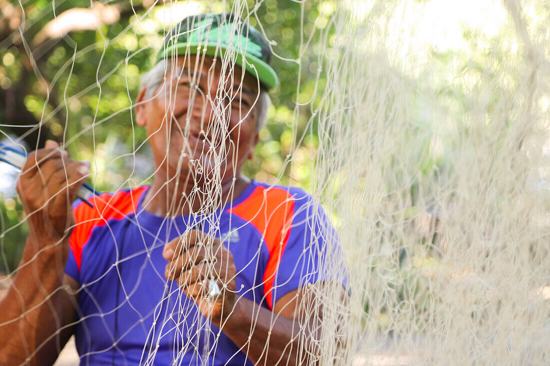 Fishermen fixing fishing net in Jiquilillo, Nicaragua