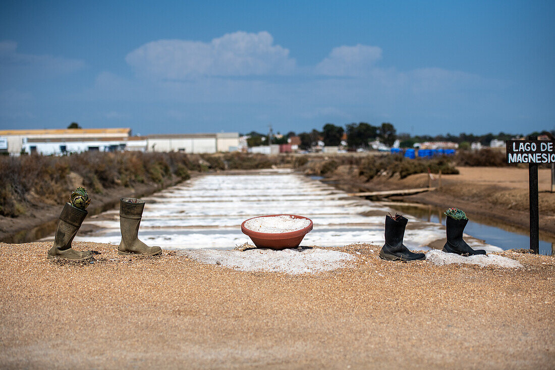Zwei Paar Stiefel und eine Schüssel voll Salz in den Salinen, Isla Cristina, Spanien