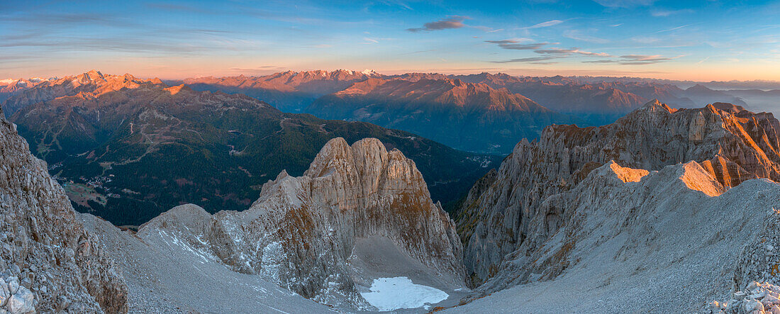 Sonnenaufgang im Gebirge, der die Gipfel des Adamello-Brenta-Parks beleuchtet, von einem Gipfel in den Brenta-Dolomiten aus gesehen, oberhalb des Tovel-Sees in der Provinz Trient, Region Trentino-Südtirol, Italien.
