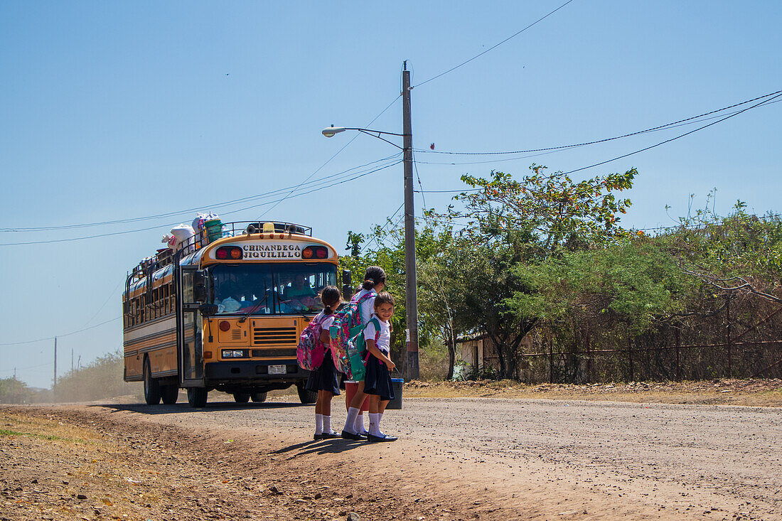 Kinder steigen in den Schulbus in Jiquilillo, Chinandega, Nicaragua