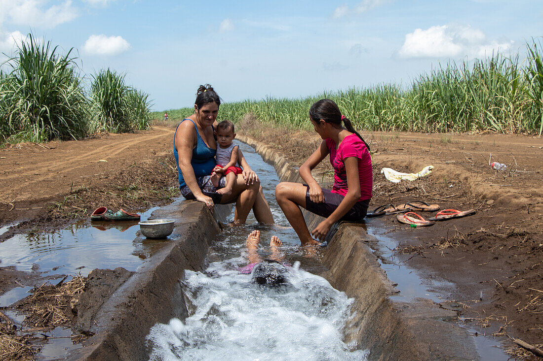 Familie spielt im Wasserkanal, Jiquilillo, Nicaragua