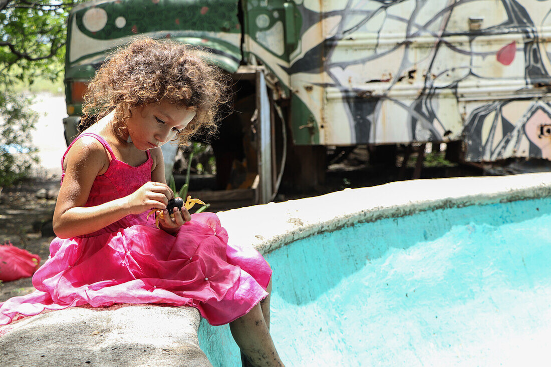 Britany, ein 4 Jahre altes Mädchen aus Jiquilillo, spielt mit einer Krabbe, Nicaragua