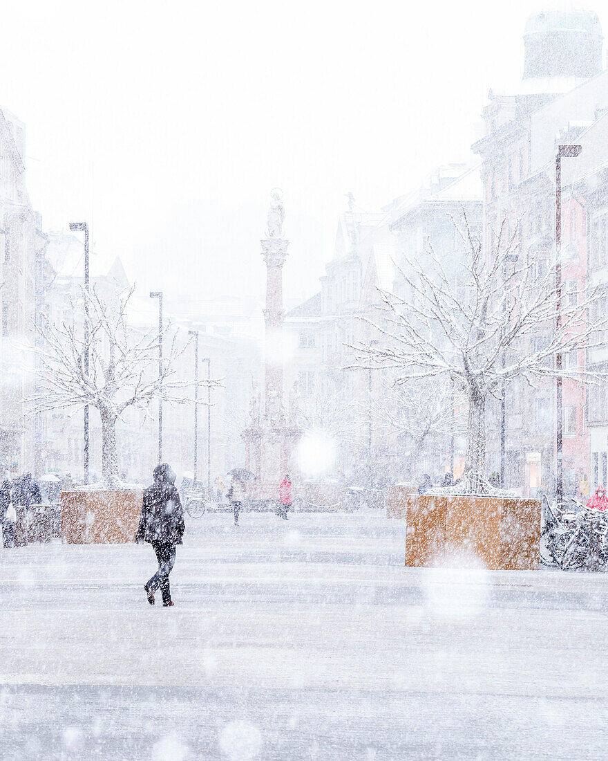 A woman walking in the Maria-Theresien-Straße on a snowy day, Innsbruck, Innsbruck Stadt, Tyrol, Austria, Europe