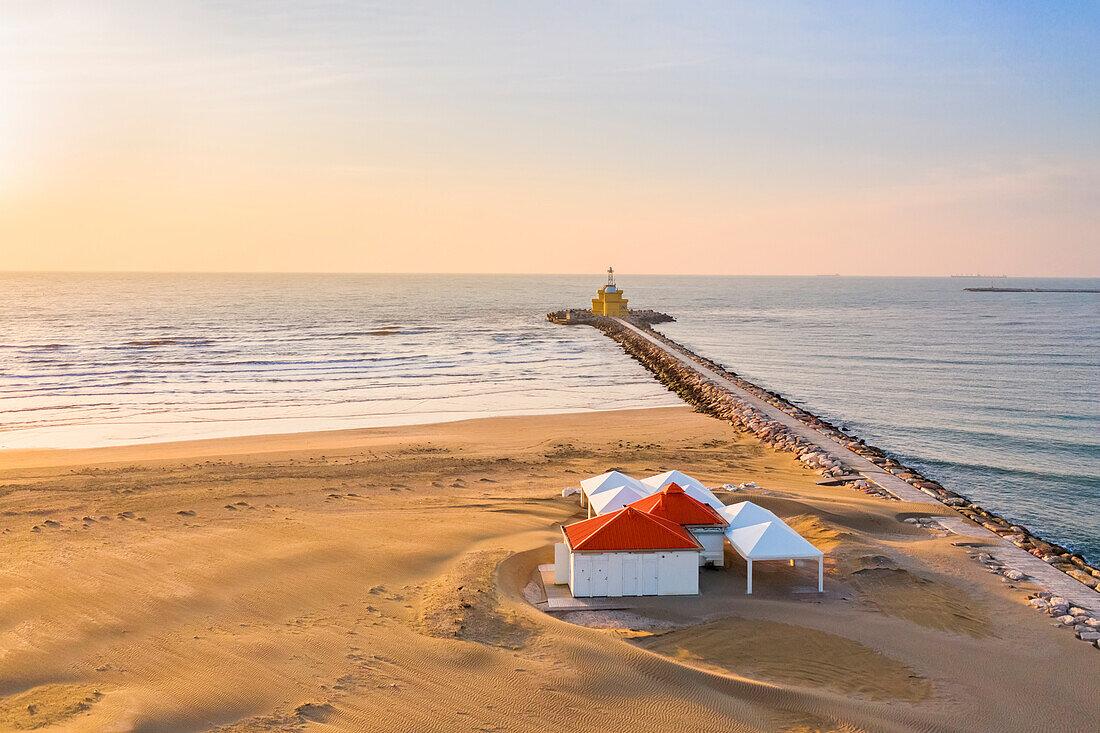Luftaufnahme des Strandes von Punta Sabbioni mit seinem Stand und seinem Leuchtturm in der Morgendämmerung, Cavallino - Treporti, Provinz Venedig, Region Veneto, Italien, Europa