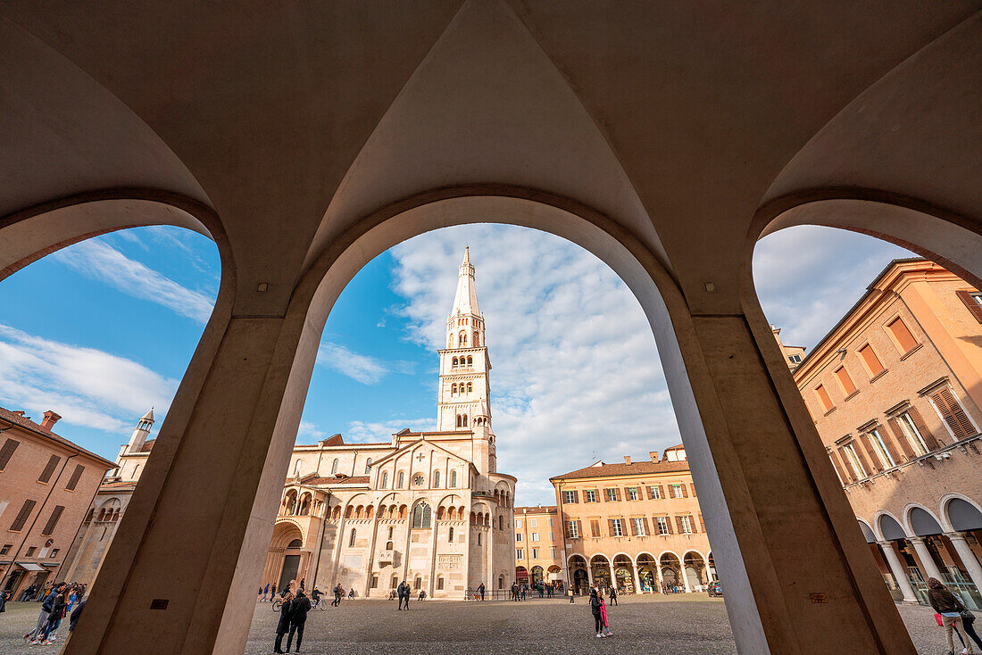 Modena, Emilia Romagna, Italien. Dom und Ghirlandina-Turm im Stadtzentrum. Blick von den Säulengängen der Piazza Grande