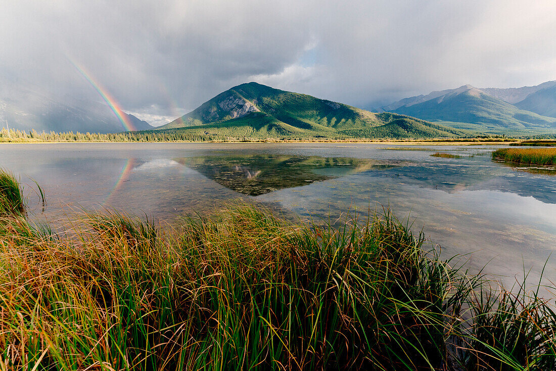 Mount Rundle und Vermillion Lakes, Banff-Jasper Nationalparks, Alberta, Kanada. Bewölkter Himmel mit Regenbogen