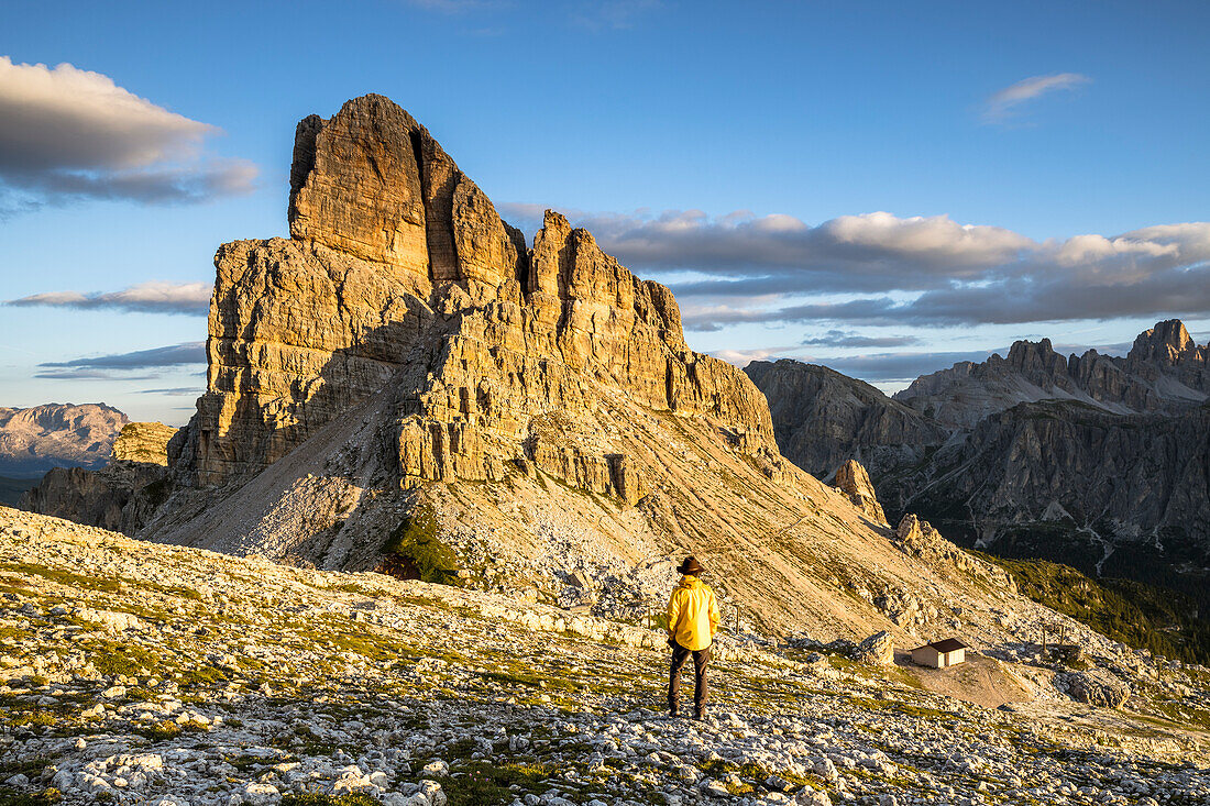 Italy, Veneto, province of Belluno, a hiker admires the sun that lights up the rocks of Mount Averau (MR)