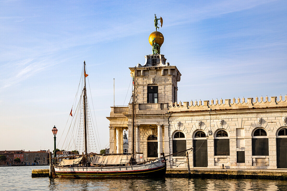 Italien, Venetien, Venedig, Punta della Dogana, überragt von einer Skulpturengruppe, die zwei Atlanten darstellt, die eine große Kugel hochhalten, an deren Spitze sich die Fortuna (Occasio) dreht und die Windrichtung anzeigt
