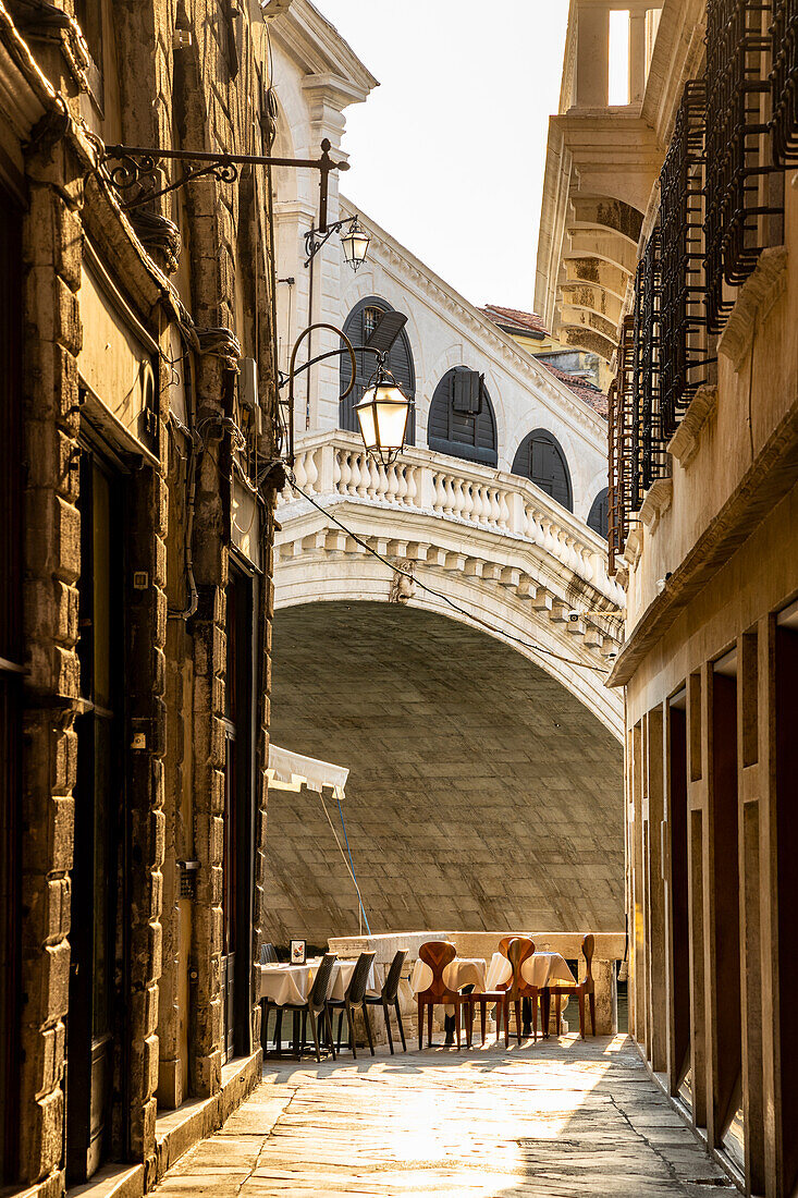 Italy, Veneto, Venice, a typical calle (street) in Venice, with Ponte di Rialto (Rialto Bridge) in the background
