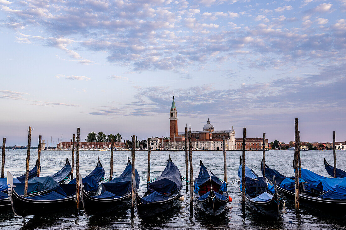 Italy, Veneto, Venice, the typical gondolas moored in the Canal Grande (Grand Canal), with the Basilica of San Giorgio Maggiore in the background at dusk