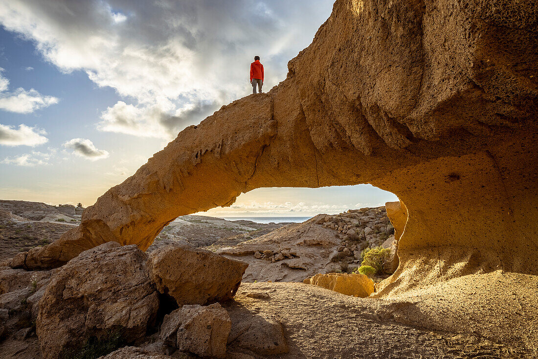 Spain,Canary Islands,Tenerife,Santa Cruz de Tenerife, a man standing on top of the natural formation of volcanic tuff of the Arco de Tajao (MR)