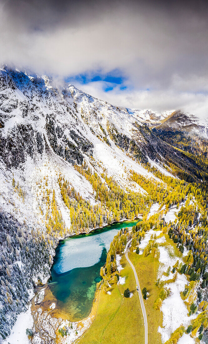 Luftaufnahme vom Palpuognasee nach einem herbstlichen Schneefall. Palpuognasee, Kanton Graubünden, Schweiz.