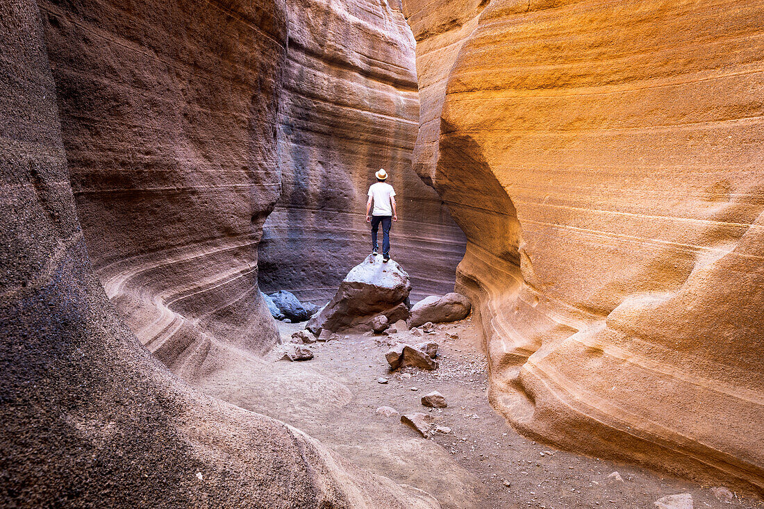 Spanien, Kanarische Inseln, Gran Canaria, Las Palmas, ein Mann steht in der Schlucht von Barranco de Las Vacas (MR)