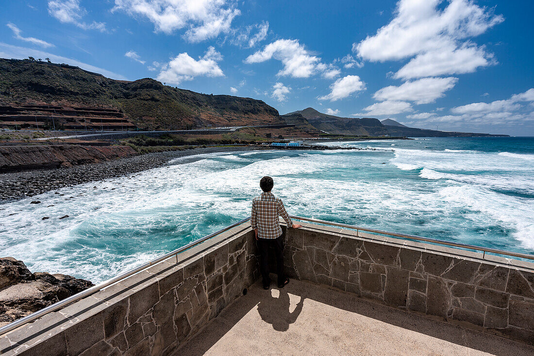 Spain, Canary Islands, Gran Canaria,El Roque, a man admires the waves from a terrace overlooking the sea (MR)